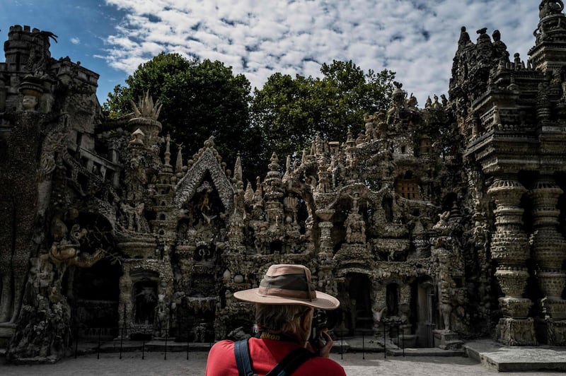 A man takes a picture as he visits the Palais Ideal (the "Ideal Palace") created by late French postman Ferdinand Cheval, better known as Facteur Cheval in Hauterives, France.  AFP