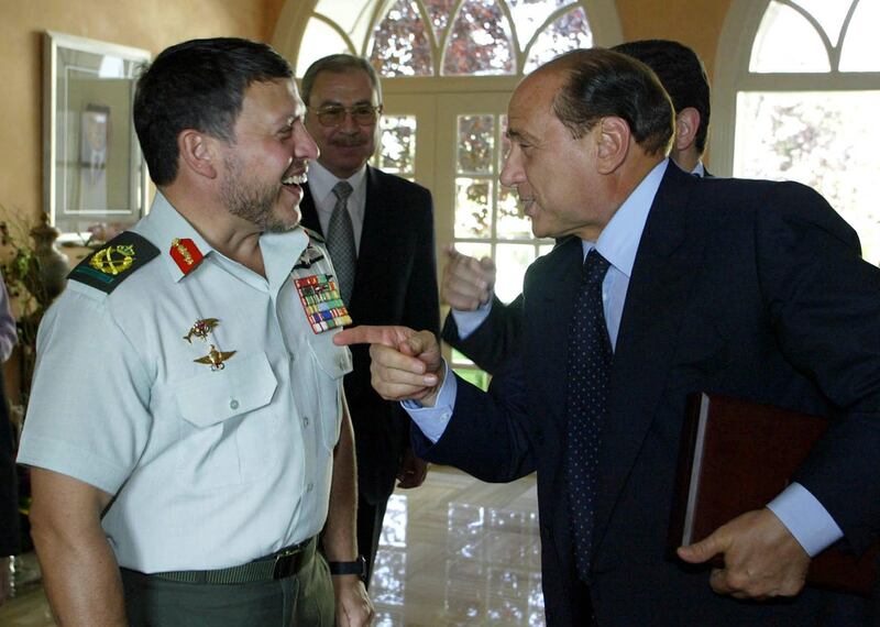 Jordan's King Abdullah II, left, laughs as he listens to Mr Berlusconi during their meeting at the royal palace in Amman, in June 2003. AFP 