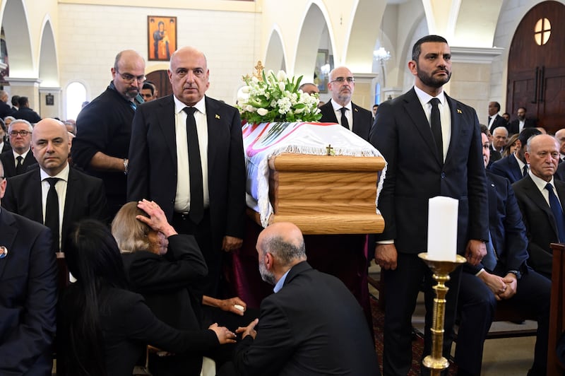 Mourners stand next to Mr Sleiman's coffin. EPA 
