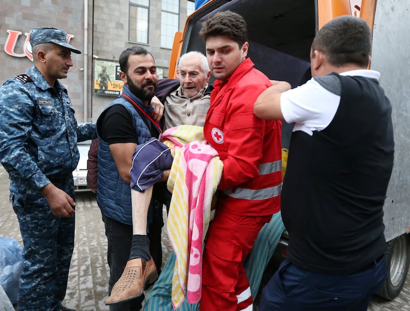 A refugee from Nagorno-Karabakh region is carried out of a vehicle upon arrival at a temporary accommodation centre in the town of Goris, Armenia. Reuters