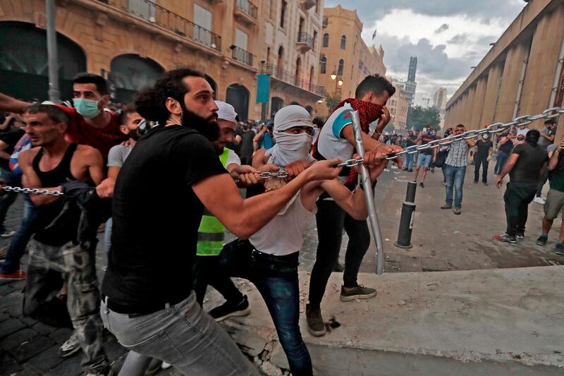 Lebanese protesters try to storm the vicinity of the parliament in central Beirut on August 10, 2020 following a huge chemical explosion that devastated large parts of the Lebanese capital.  / AFP / JOSEPH EID
