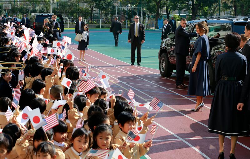 US first lady Melania Trump is waved by schoolchildren with national flags of Japan and the US as she leaves after visiting Kyobashi Tsukiji Elementary School in Tokyo. Shizuo Kambayashi / AP Photo