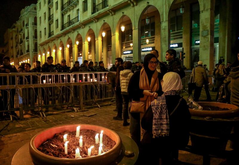 Lebanese anti-government protesters carry candles and national flags in Beirut.  EPA
