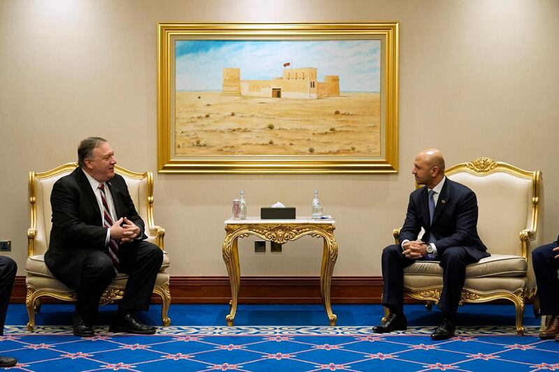 US Secretary of State Mike Pompeo talks to Afghanistan's State Minister for Peace Sayed Sadat Mansoor Naderi in Doha last November. The Afghan government and the Taliban are trying to hammer out a peace deal. AP