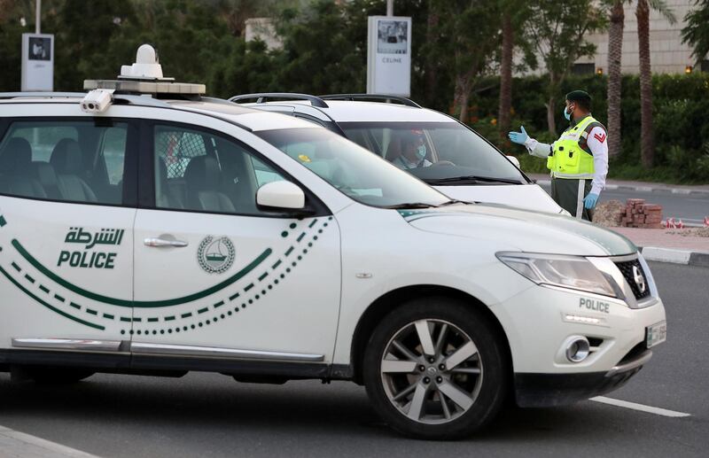 DUBAI, UNITED ARAB EMIRATES , April 16– 2020 :- Dubai Police officer stopping the private vehicles and checking the movement permit near Madinat Jumeirah in Dubai. Dubai is conducting 24 hours sterilisation programme across all areas and communities in the Emirate and told residents to stay at home. UAE government told residents to wear face mask and gloves all the times outside the home whether they are showing symptoms of Covid-19 or not.  (Pawan Singh / The National) For News/Online/Instagram