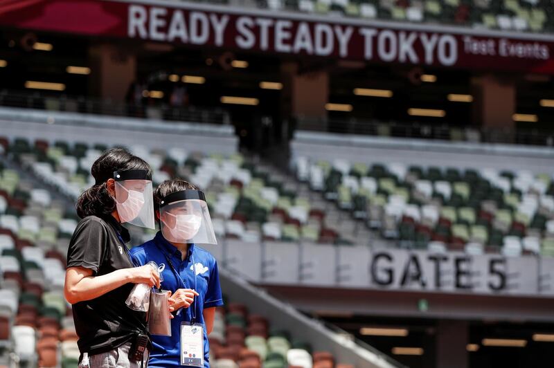 Officials wear face masks and shields during the morning session of the athletics test event. Reuters