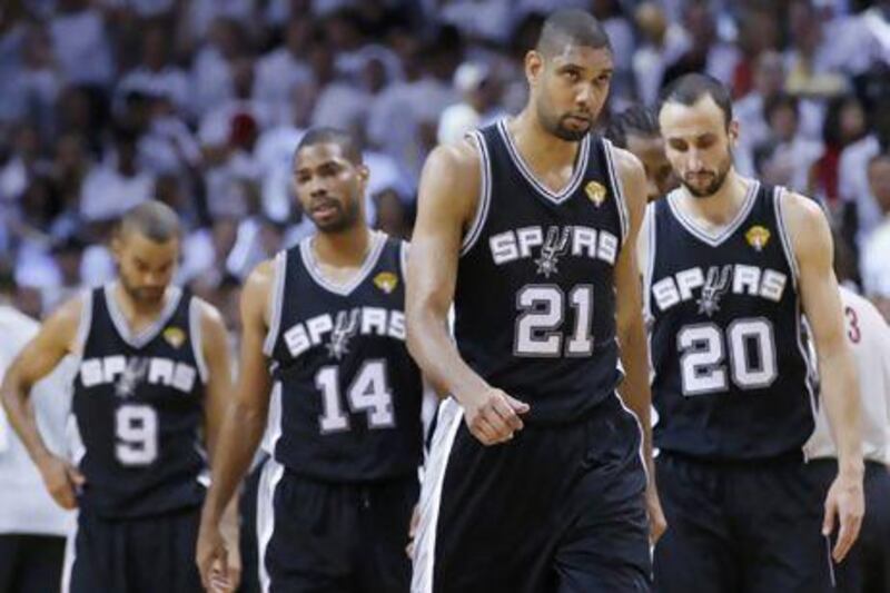 San Antonio Spurs' Tim Duncan, second from right, leads his teammates Manu Ginobili (20), Gary Neal (14) and Tony Parker (9) off the court. Duncan says the Game 7 loss to the Miami Heat will 'haunt' him.