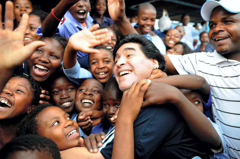 WINTERVELDT, SOUTH AFRICA - JANUARY 19:  In this handout photo provided by 2010 FIFA World Cup Organising Committee South Africa, Argentina national soccer team's head coach Diego Maradona is greeted by schoolchildren during his visit to Kgotlelelang School at Winterveldt on January 19, 2010, around 40km north west of Pretoria, South Africa.  (Photo by 2010 FIFA World Cup Organising Committee South Africa via Getty Images)