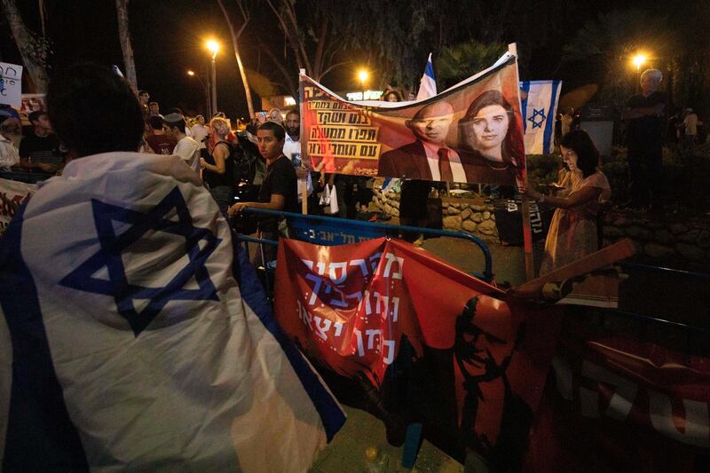 Israeli right-wing activists hold signs showing Naftali Bennett and Ayelet Shaked of the Yamina party, during a demonstration against the possibility of forming a new government in Tel Aviv, Israel. AP Photo