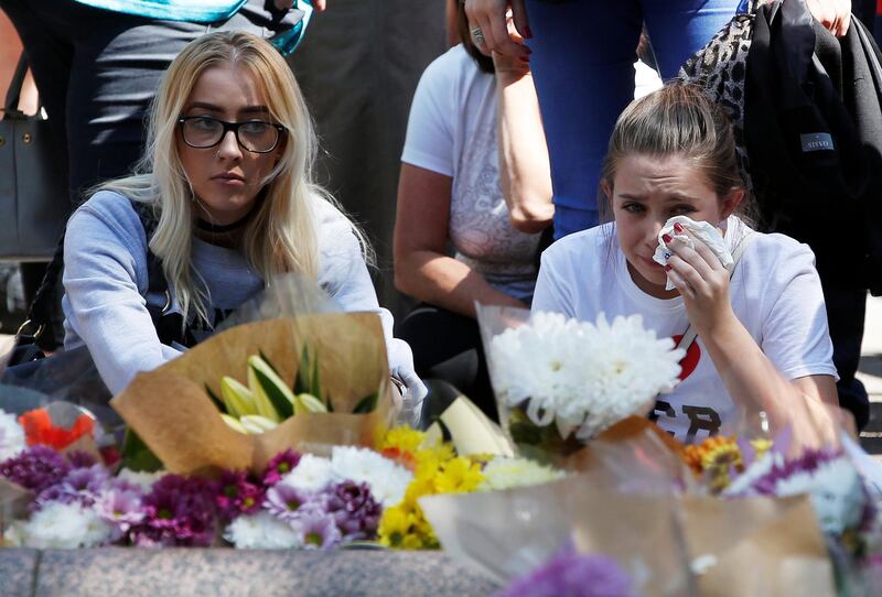 A girl cries as she looks at at tributes left in St Anne's Square on the first anniversary of the Manchester Arena bombing. Reuters