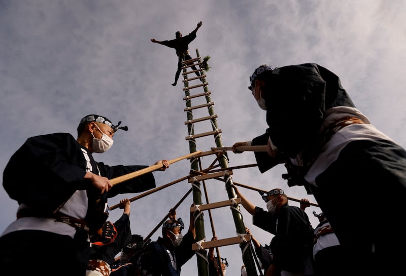 A member of the Edo Firemanship Preservation Association displays his balancing skills atop a bamboo ladder during Tokyo Fire Department's New Year's Fire review in Tokyo, Japan January 6, 2023.   REUTERS / Issei Kato     TPX IMAGES OF THE DAY