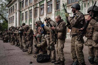 Ukrainian soldiers unload their guns as they arrive at an abandoned building to rest and receive medical treatment after fighting on the front line for two months near Kramatorsk, eastern Ukraine. AFP