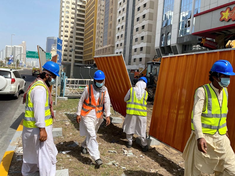 Workers board up a building on Airport Road in Abu Dhabi on Tuesday, September 1, a day after the deadly gas blast. The National