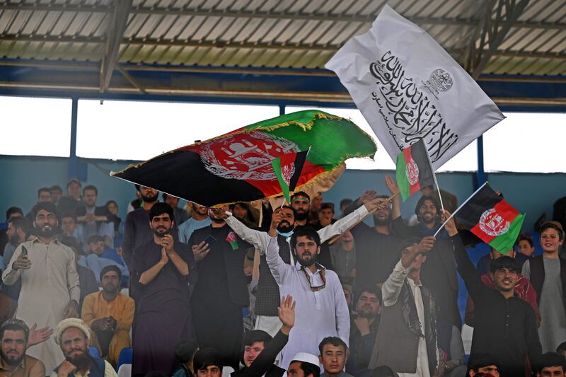 Spectators wave Afghanistan's and Taliban flags as they watch the Twenty20 cricket trial match being played between two Afghan teams, Peace Defenders and Peace Heroes, at the Kabul International Cricket Stadium. AFP