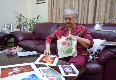 Nira Varma shows her unframed cross stitch pieces. Photo: Khushnum Bhandari / The National
