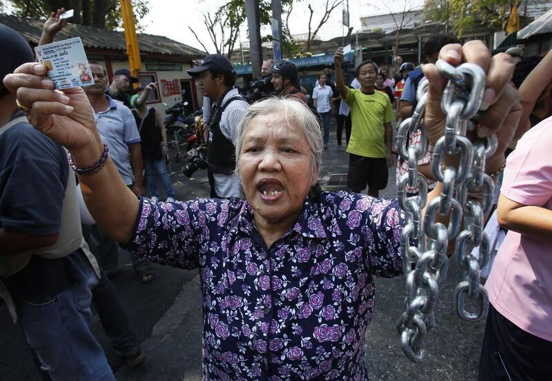 A voter holds the chains that held the gate of the polling station closed, demanding the right to vote in Bangkok. The national focus was riveted on the capital where 488 of the city’s 6,600 polling stations were shut and several skirmishes broke out between protesters intent on disrupting the vote and frustrated would-be voters. AP Photo