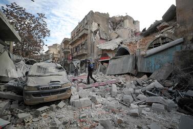 A Syrian walks on the rubble of a building following a regime air strike on Ariha town. AFP
