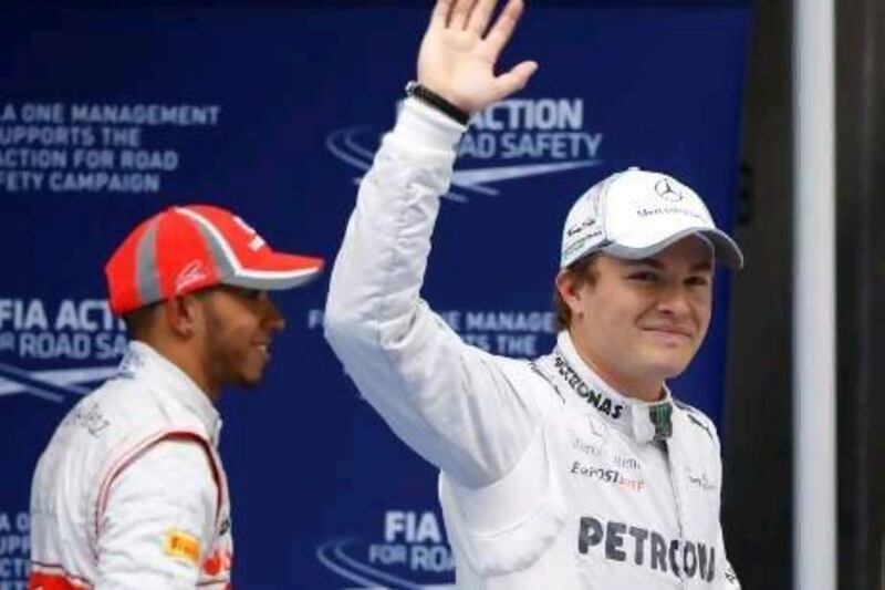 Nico Rosberg of Germany, right, acknowledges the cheers of the crowd in Shanghai after winning his first Formula One pole.