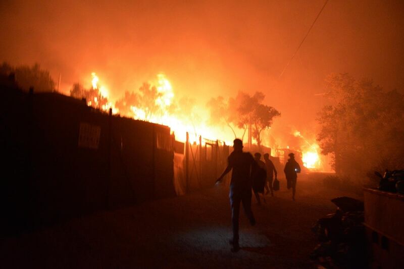 Refugees run as fire burns in the Moria camp on the northeastern Aegean island of Lesbos, Greece. AP Photo