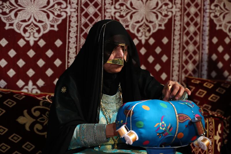 A member of the General Women's Union demonstrates traditional Emirati crafts to visitors