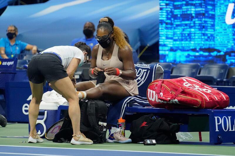 Serena Williams has her ankle taped by a trainer during a medical timeout during the US Open semi-final against Victoria Azarenka. AP
