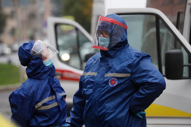 Emergency paramedics wearing protective equipment wait near ambulances to deliver patients to the admissions department at the Pokrovskaya hospital in St Petersburg, Russia, where patients infected with the Covid-19 are treated. EPA