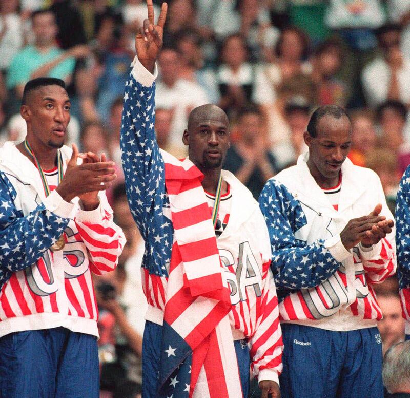 United States' Michael Jordan, centre, poses with his gold medal and a flag draped over his shoulder at the 1992 Olympics in Barcelona.  (AP Photo/Susan Ragan, File)