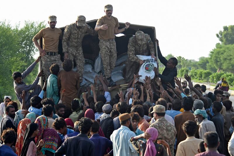 Pakistan Army soldiers in Shikarpur, Sindh province, distribute relief food bags to people who escaped the floods. AFP