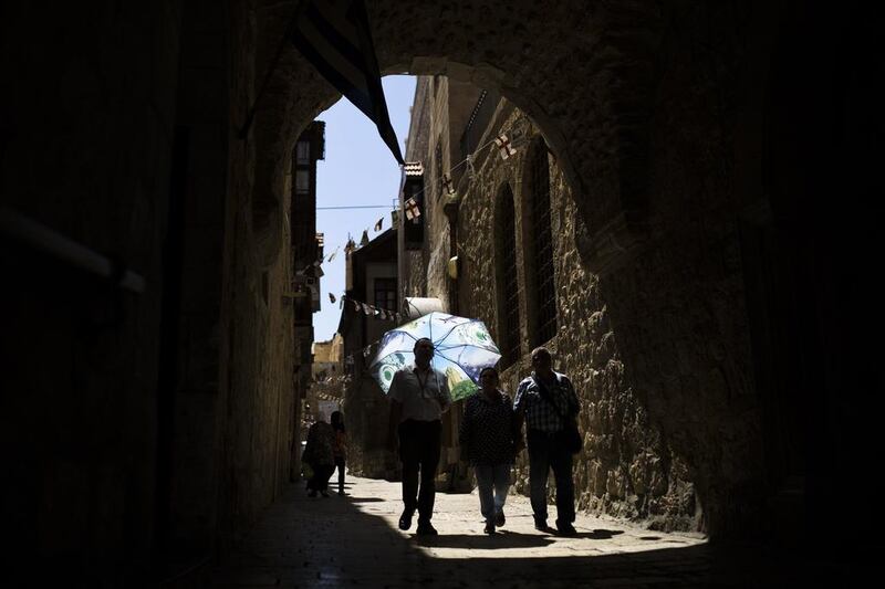 Tourists walk in an alley of Jerusalem’s Old City. Amir Cohen / Reuters / April 25, 2014