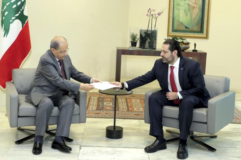 In this handout picture provided by the Lebanese photo agency Dalati and Nohra, Lebanon's Prime Minister Saad Hariri (R) hands President Michel Aoun his government's resignation at the Baabda presidential palace, east of the capital Beirut, on October 29, 2019, bowing to nearly two weeks of unprecedented nationwide protests. - Hariri's televised address announcing the resignation was met by cheers from crowds of protesters who have remained mobilised since October 17, crippling the country to press their demands. (Photo by - / DALATI AND NOHRA / AFP) / === RESTRICTED TO EDITORIAL USE - MANDATORY CREDIT "AFP PHOTO / HO / DALATI AND NOHRA" - NO MARKETING - NO ADVERTISING CAMPAIGNS - DISTRIBUTED AS A SERVICE TO CLIENTS ===
