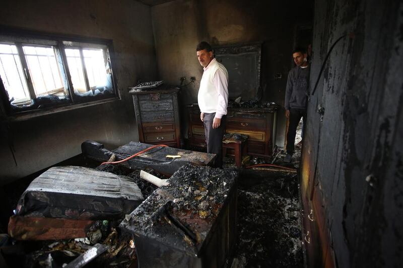 Palestinians inspecting the damage at the burned house of Ibrahim Dawabsha, from the West Bank village of Duma on 20 March 2016. Mr Dawabsha is a key witness in the firebombing attack carried out by Jewish extremists on July 2015 against his relatives which kiled an 18-month-old boy along with his two parents. EPA