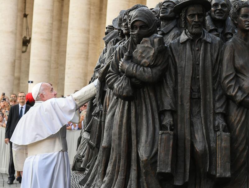 Pope Francis (L) attends the unveiling of a sculpture called "Angels Unaware" by Canadian sculptor Timothy P. Schmalz depicting a group of 140 migrants of various cultures and from different  historic times, following a mass for World Day of Migrants and Refugees on September 29, 2019 at St. Peter's Square in the Vatican.  The sculpture is inspired by the passage from the Letter to the Hebrews "Do not neglect hospitality, for through it some have unknowingly entertained angels".  / AFP / POOL / Vincenzo PINTO                      
