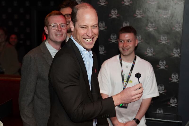 Prince William takes part in a game of interactive darts at the 180 Club during a visit to The Rectory. AP