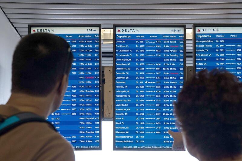 Travellers check the Delta departures board at LaGuardia Airport, in the Queens borough of New York City. AFP