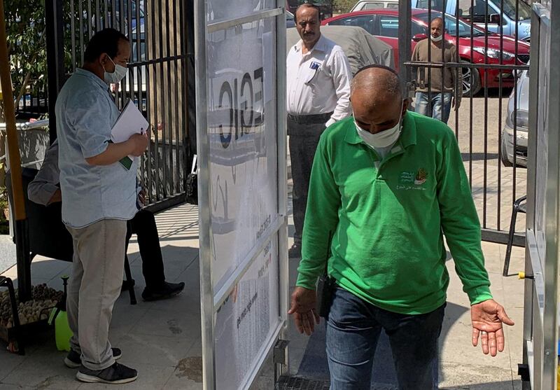 A man wears a protective face mask while walking through a sanitizing gate in Cairo. Reuters