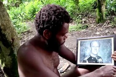 A man holds a picture of Britain's Prince Philip as late Duke's devotees hold a mourning ceremony in his honour on the island of Tanna in Vanuatu in this screengrab taken from a video on April 12, 2021. REUTERS TV via REUTERS