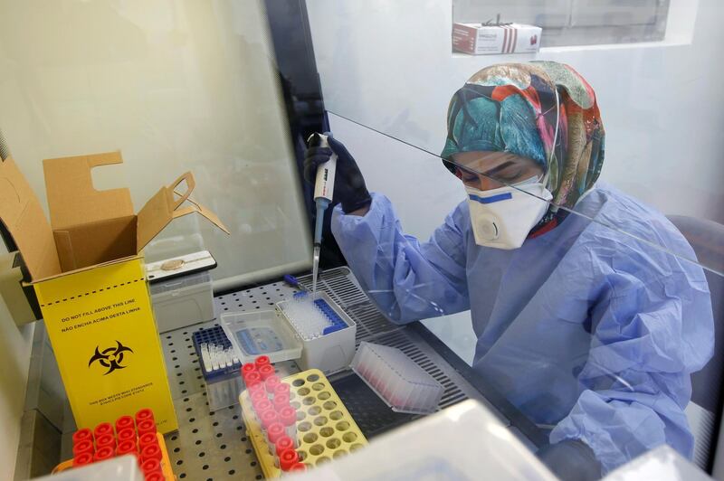 A medical team member wearing a protective suit and a face mask, works on blood samples to be tested for coronavirus disease (COVID-19), at a medical center in a hospital in the holy city of Najaf, Iraq February 15, 2021. REUTERS/Alaa al-Marjani