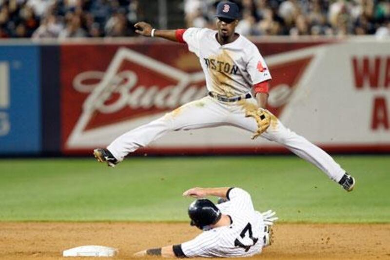 Boston's Pedro Ciriaco jumps over Jayson Nix of the Yankees as he turns a double play during their fixture in New York