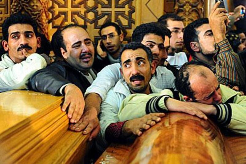 Egyptian Christians grieve in front of coffins containing the victims of a bomb attack in Alexandria in January last year.