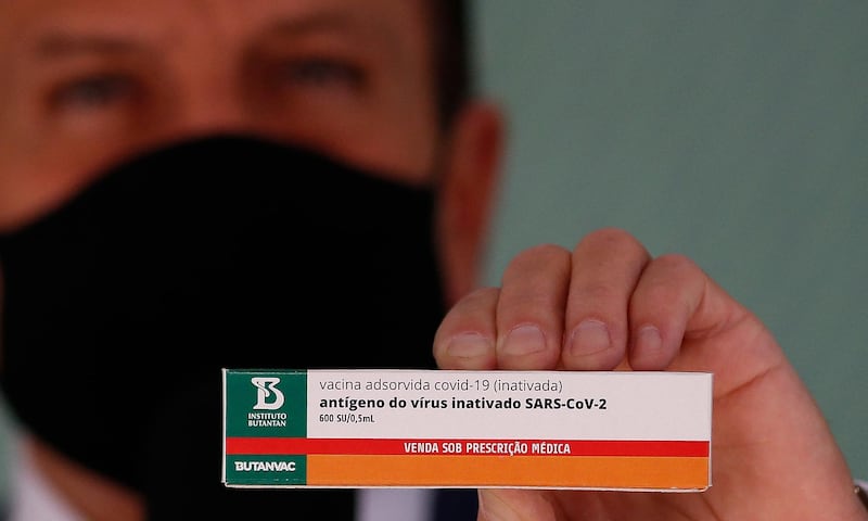 Sao Paulo Governor Joao Doria shows the ButanVac vaccine candidate against Covid-19, at the Butantan Institute, in Sao Paulo, Brazil, on March 26, 2021. - The Brazilian ButanVac vaccine will ask for authorization from the National Health Surveillance Agency (Anvisa) to start clinical trials of phases 1 and 2 in humans, involving 1,8 thousand volunteers. Research started on March 26, 2020 and the production goal is to start on May and to deliver 40 million doses starting on July, 2021. (Photo by Miguel SCHINCARIOL / AFP)