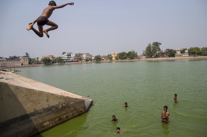A Nepalese boy jumps into the Ganga Sagar pond during a hot day in Terai, Nepal., Nepal registered a record high temperature of 40 degrees.  EPA