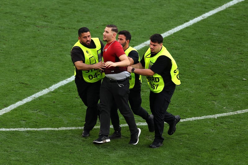 One of several pitch invaders is led away. Getty Images