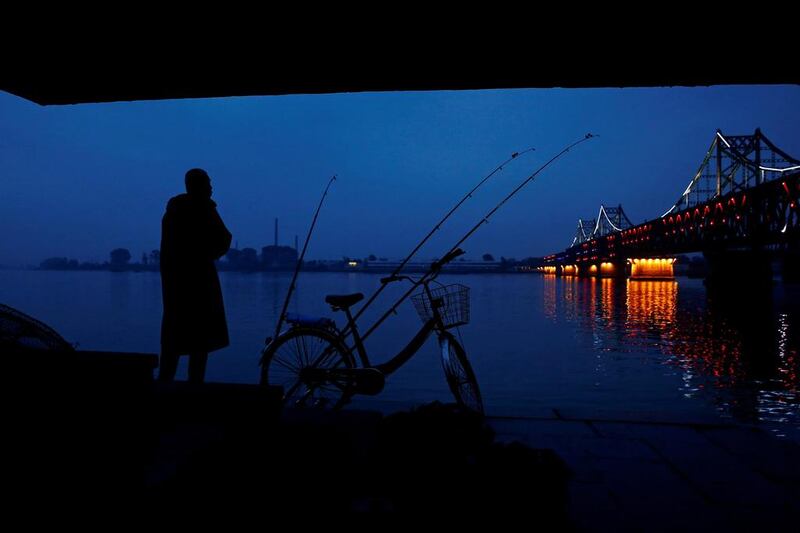 A man looks across Yalu River towards North Korea as he stands next to the bridge that connects China’s Dandong, Liaoning province and North Korea’s Sinuiju. Thomas Peter / Reuters