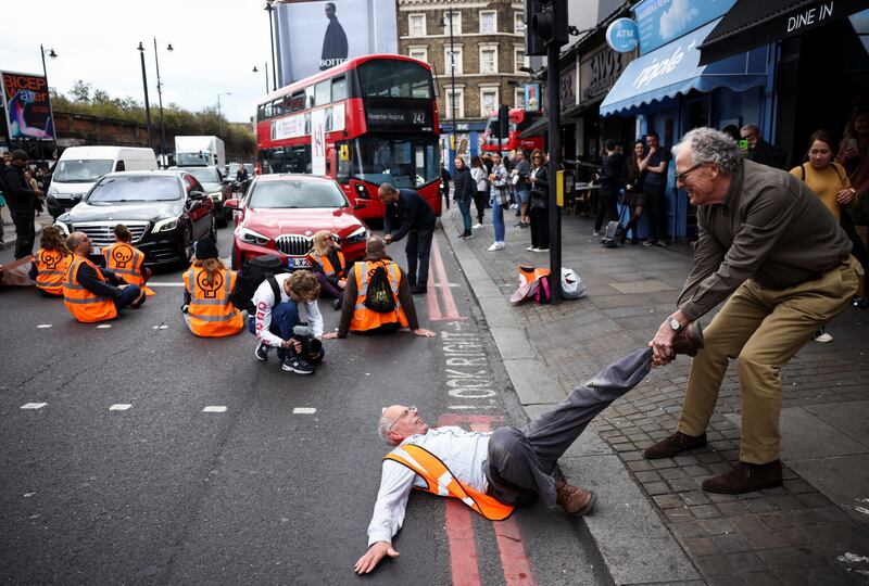 A member of the public drags an activist blocking the road during a Just Stop Oil protest in London. Reuters