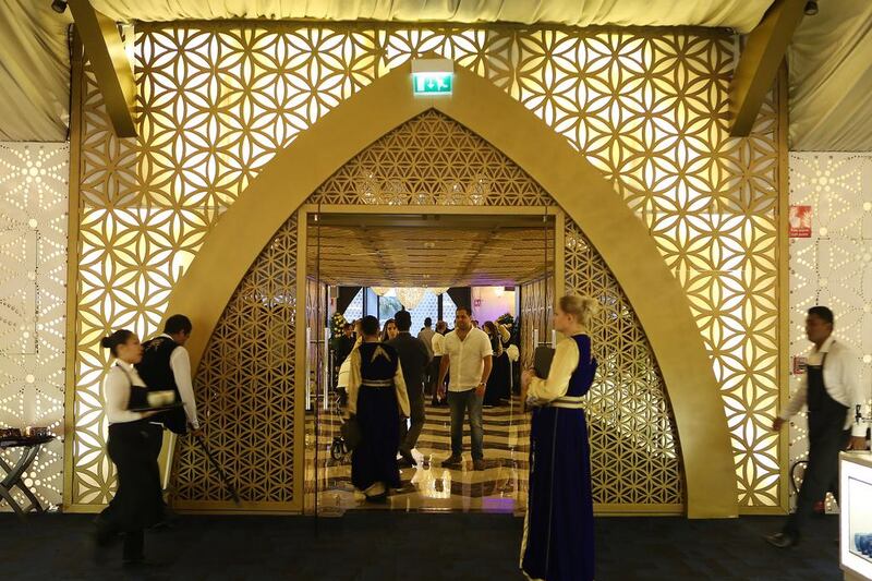 Staff wait to greet guests at the entrance of the Asateer iftar tent.