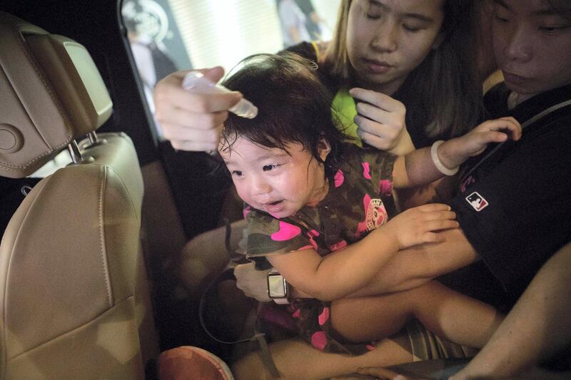 HONG KONG.
SCHOOL BUS FEATURE:
A young girl is treated by a medic in the back of Chen's car after being effected by tear gas during protests in the Mong Kok area of Hong Kong.
'School Buses', are the collective name to a group of volunteers, including Chen, who offer free transport for people who need help getting away from the protests safely. 