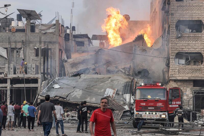 Firefighters attend a burning building after an Israeli bombardment in Gaza City. AFP