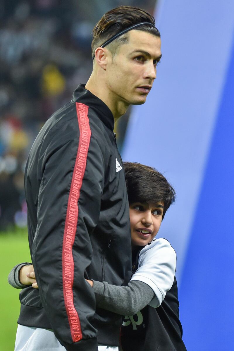 A young mascot hugs Juventus' Portuguese forward Cristiano Ronaldo. AFP