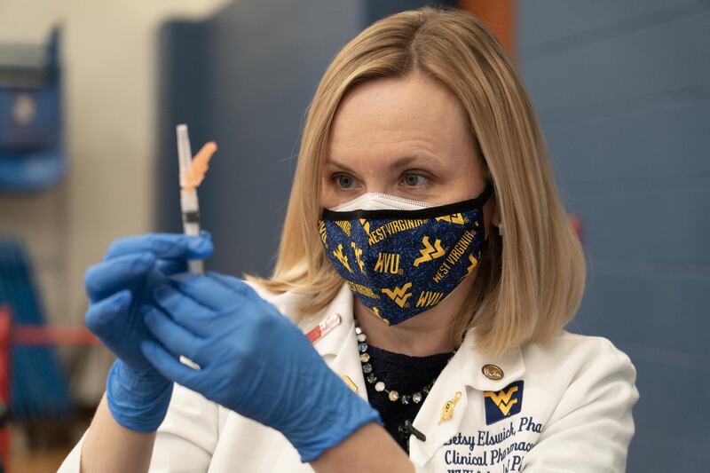 Betsy Elswick, a pharmacist at West Virginia University in Morgantown inspects a vial of vaccine. Willy Lowry / The National