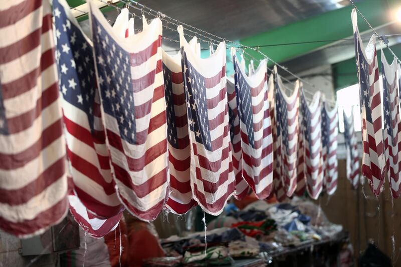 Iranian workers collect altered Israeli flags at a large factory that males US and Israeli flags for Iranian protesters to burn in Khomein City. West Asia News Agency via Reuters